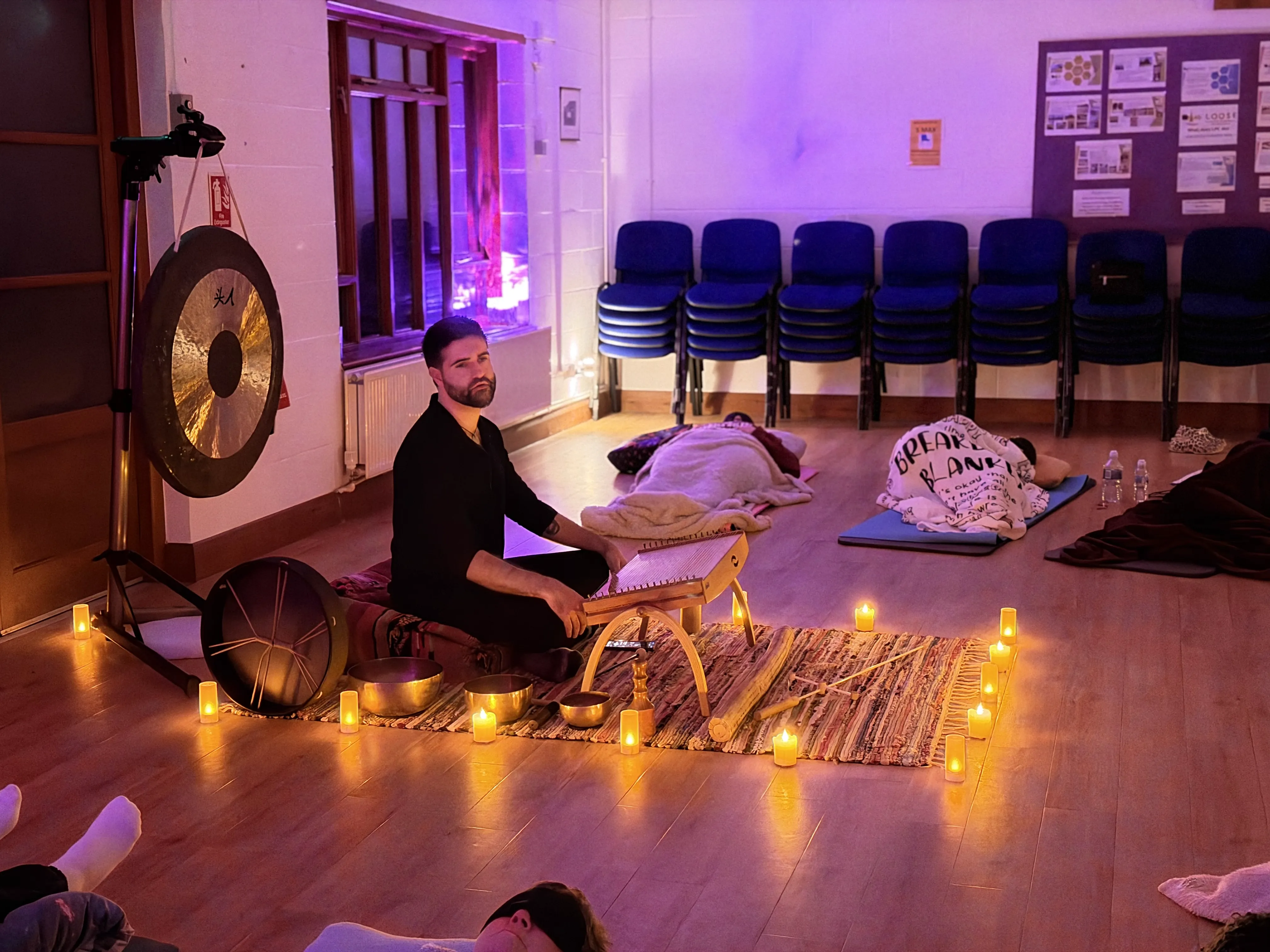 Sound bath session with singing bowls and participants resting on mats